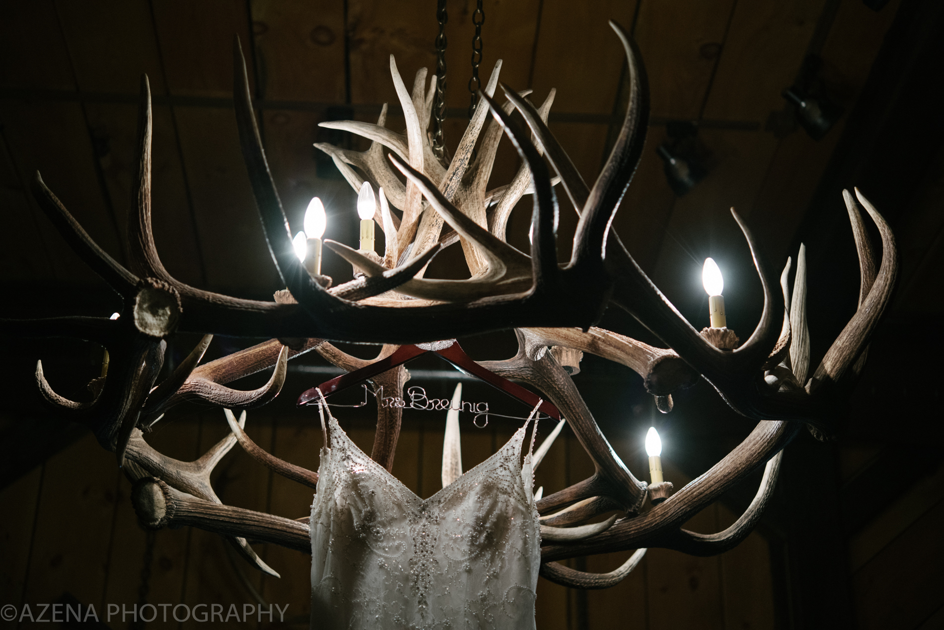 Wedding Dress hanging from antler chandelier