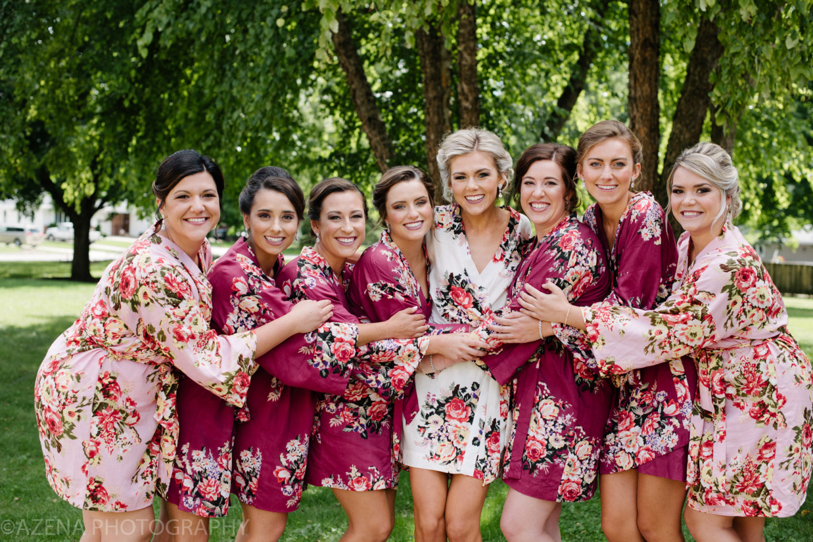 Bridesmaids laughing and wearing matching floral robes