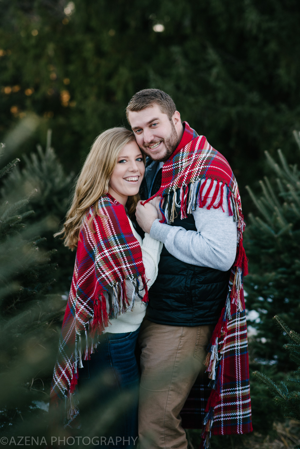 engagement session at christmas tree farm with blanket