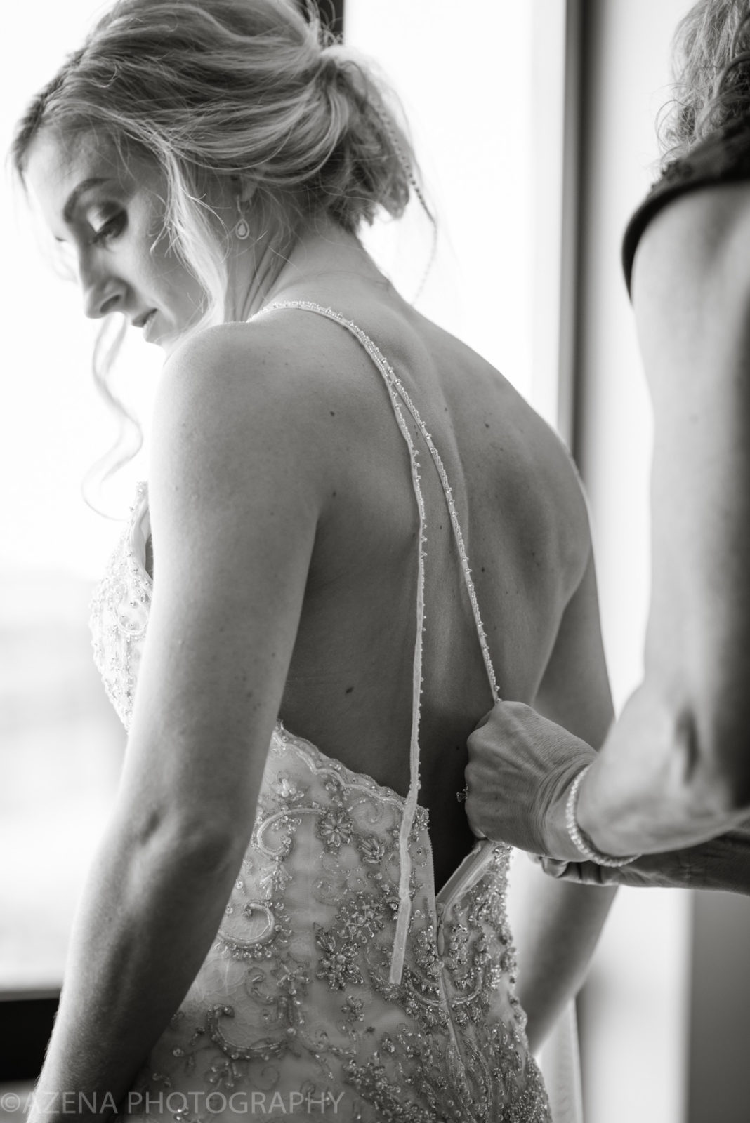 bride having dress zipped up