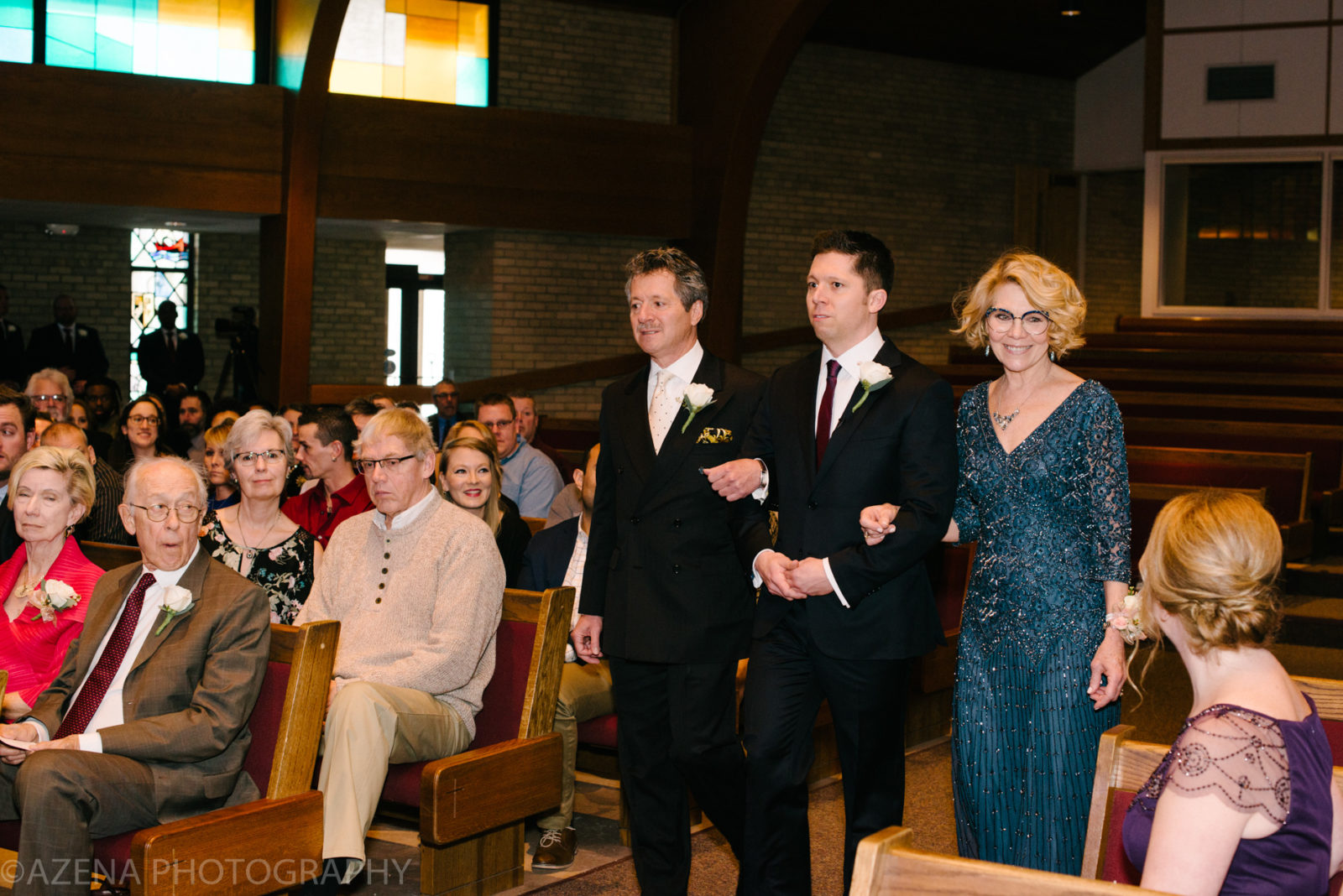 groom walking down the isle with parents