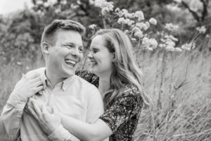 black and white photo of a couple laughing together during engagement session at Owen Conservancy in Madison, WI