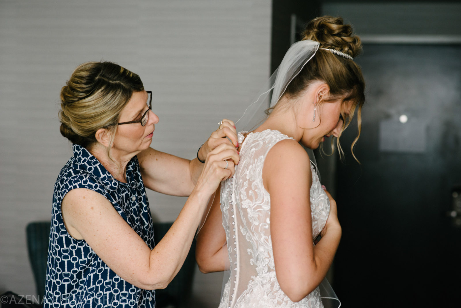 mother of the bride buttoning up wedding dress